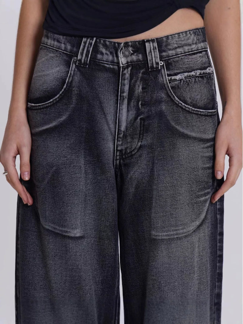 Person wearing black jeans on a plain background