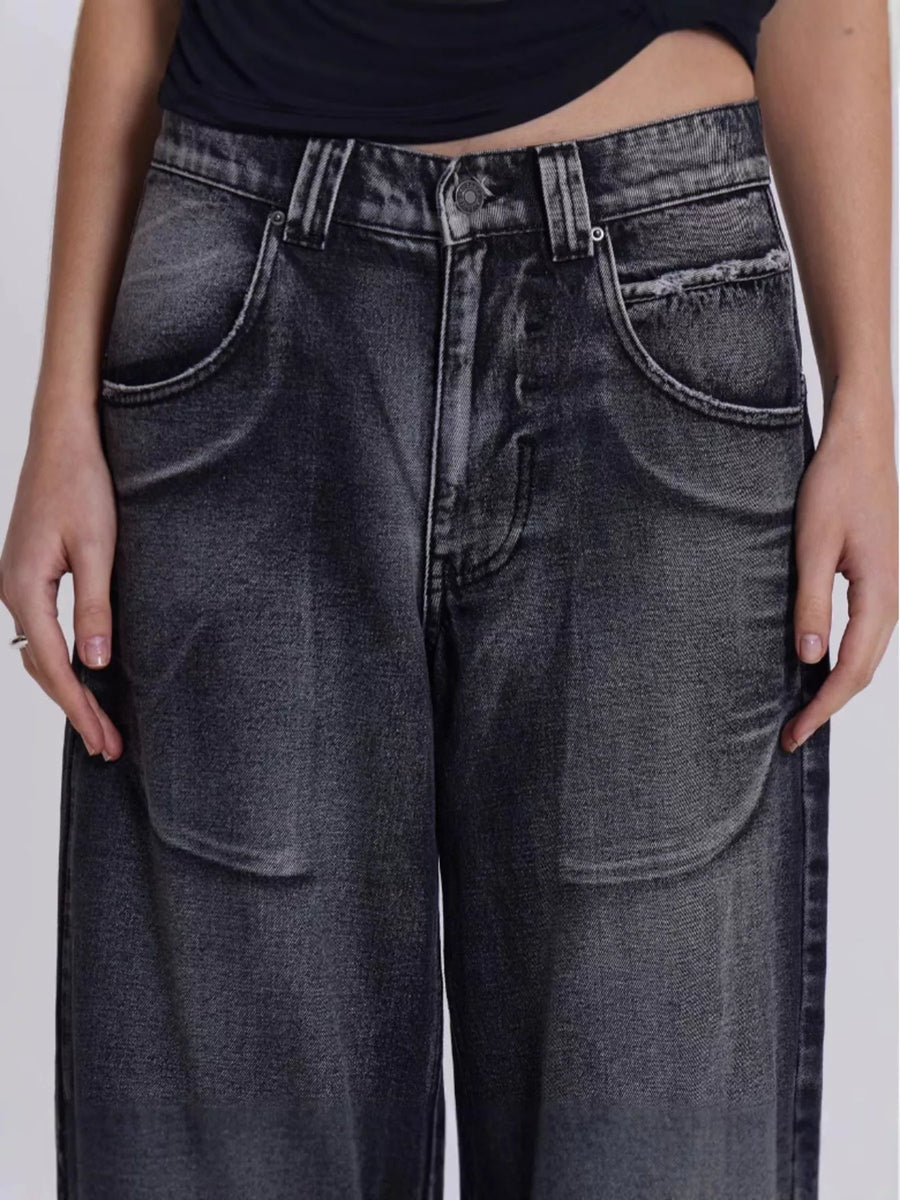 Person wearing black jeans on a plain background