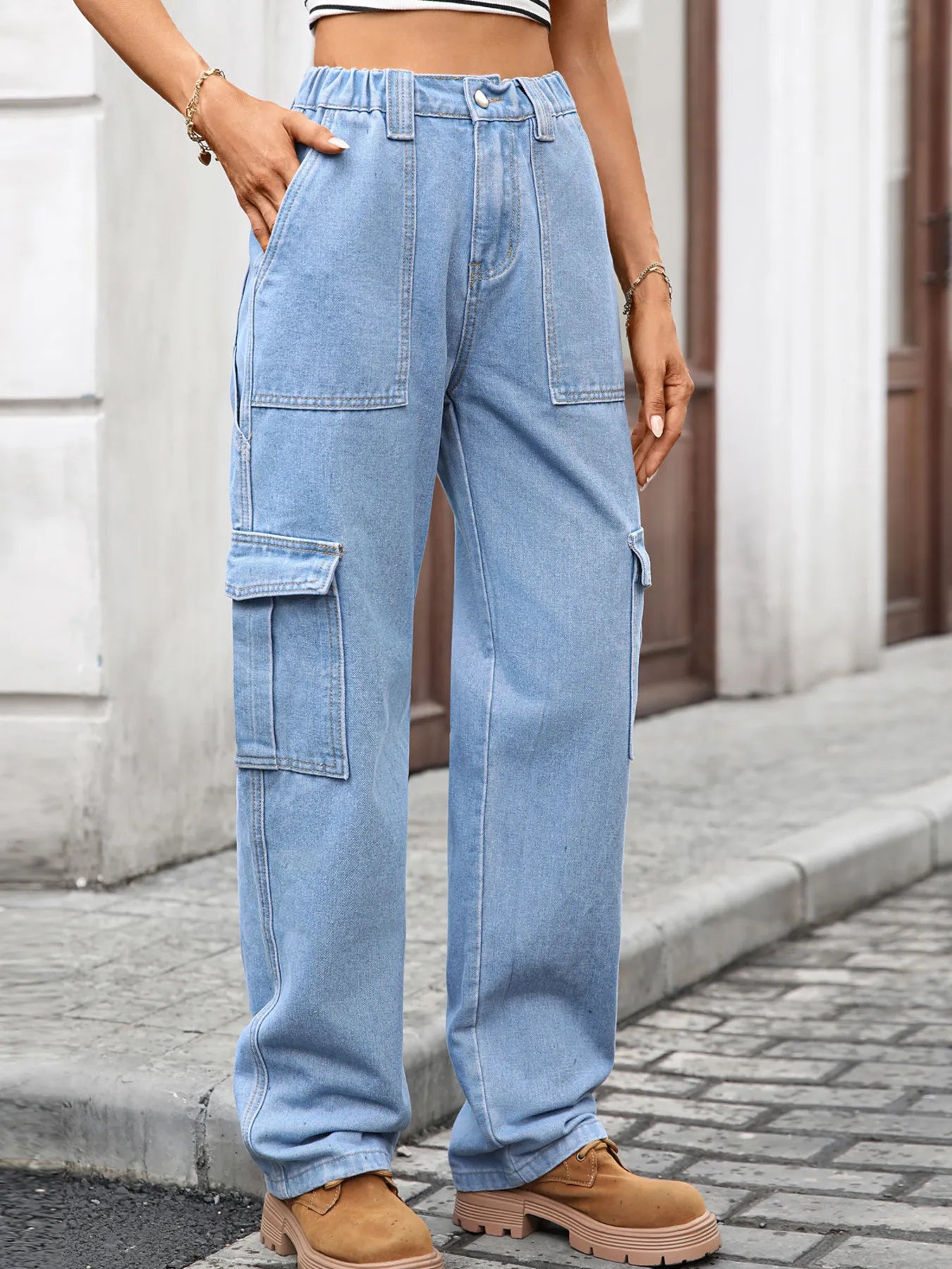 Person wearing light blue cargo pants on a street.