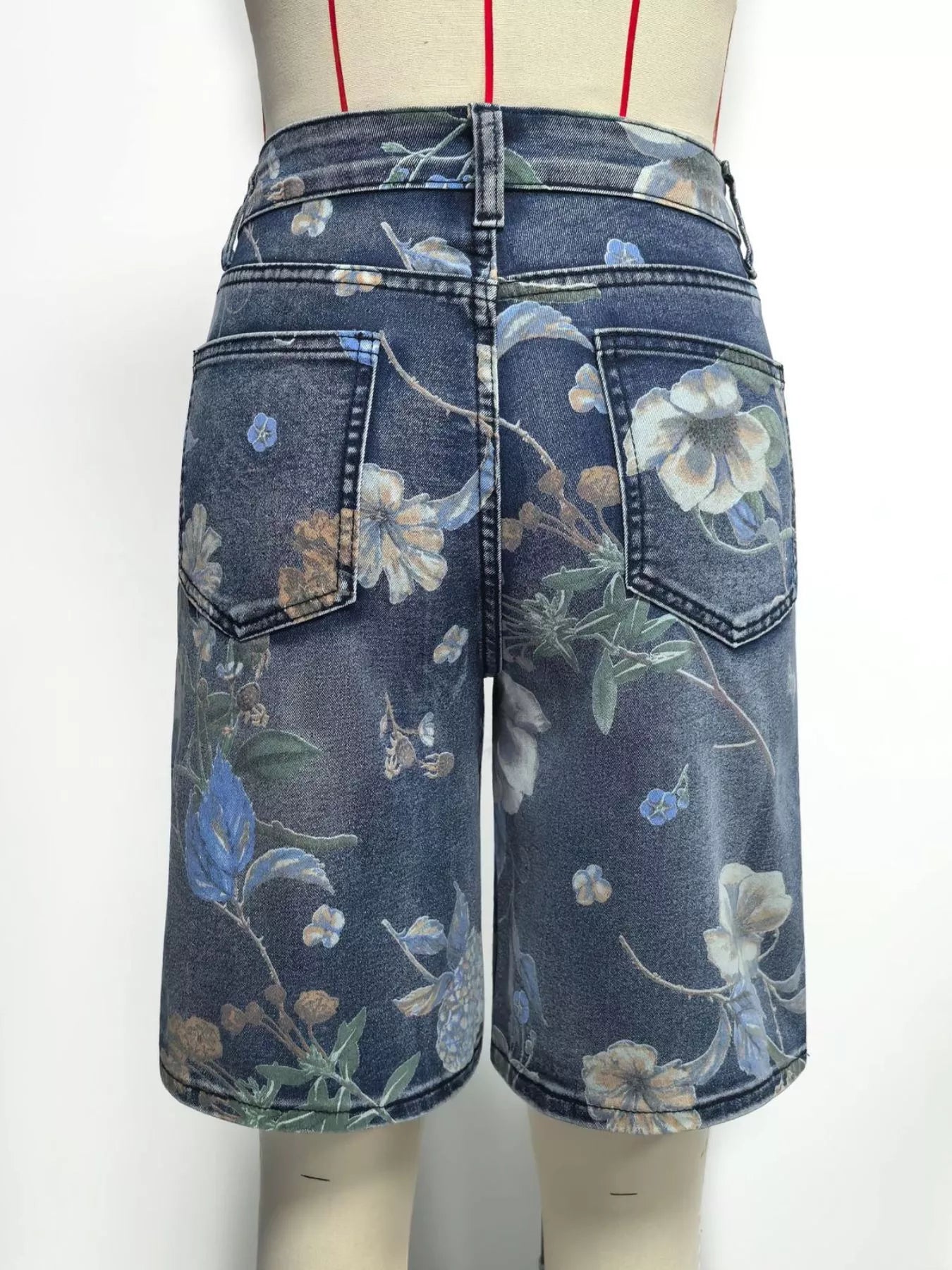 Denim skirt with floral pattern on a mannequin against a white background