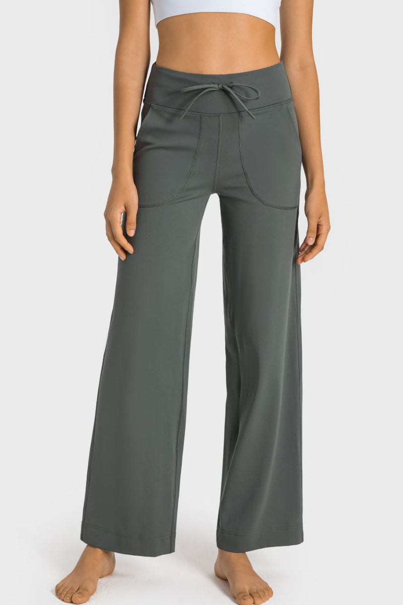 Person wearing gray wide-leg pants on a white background