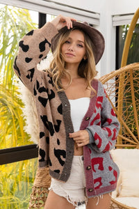 Woman wearing a patterned cardigan with a blurred outdoor background