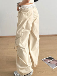 Beige cargo pants worn by a person on a wooden floor with a magazine in the background.
