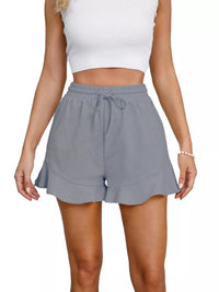Gray shorts worn by a person on a white background