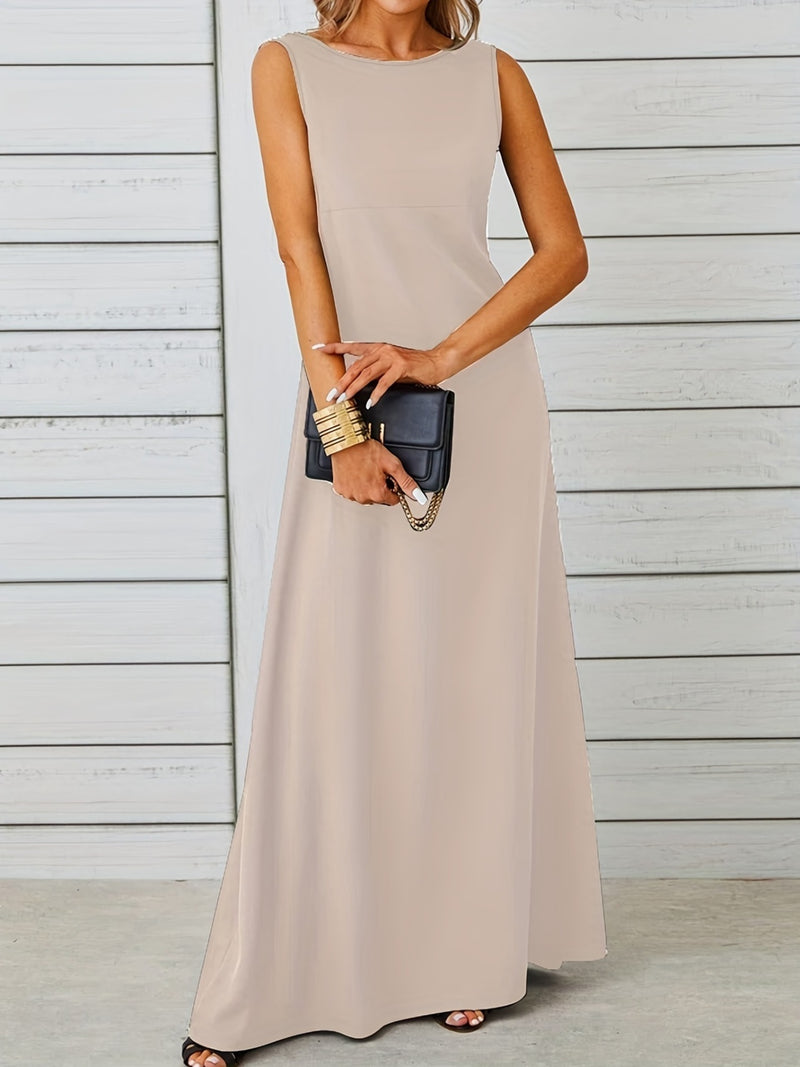 Woman wearing a beige sleeveless dress holding a black clutch against a light wooden panel background