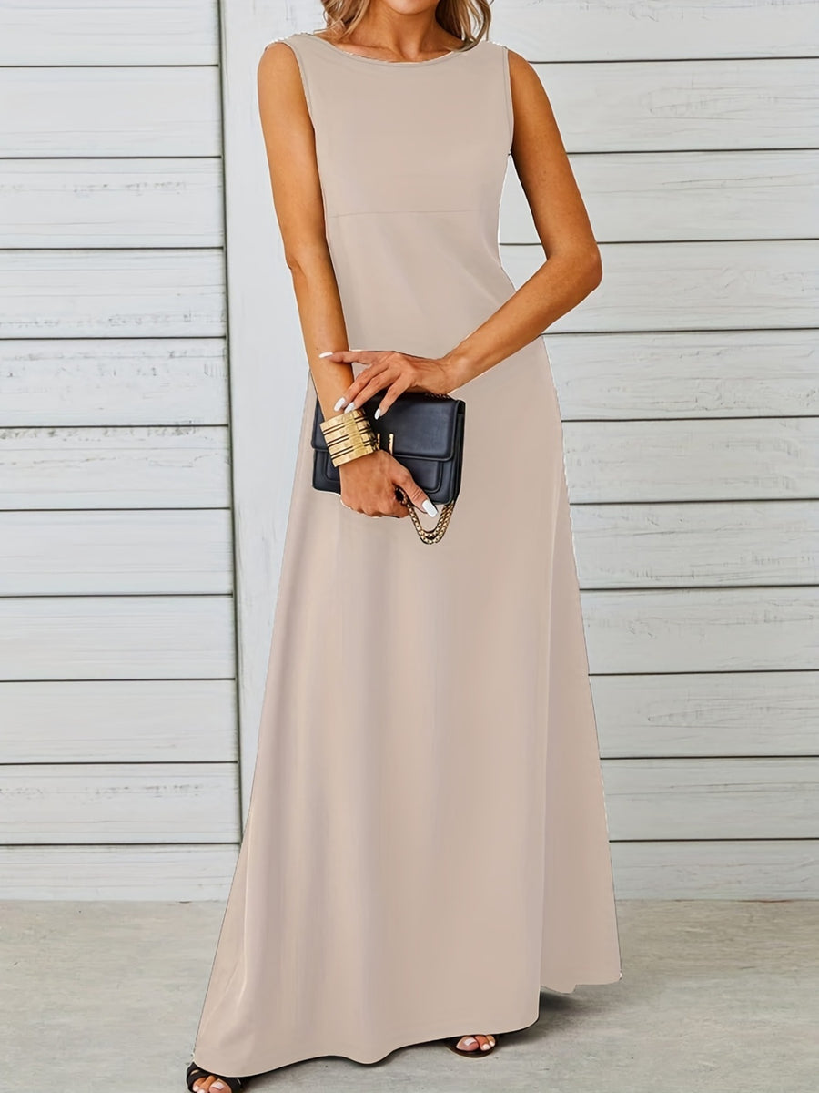 Woman wearing a beige sleeveless dress holding a black clutch against a light wooden panel background