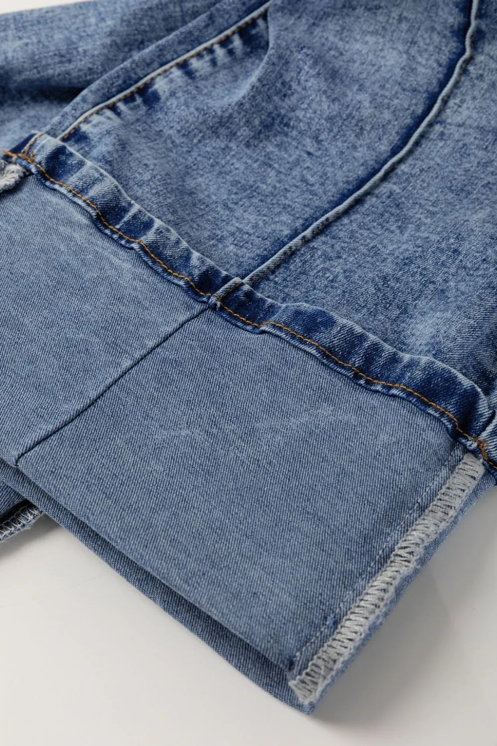 Close-up of blue denim jeans with a white background
