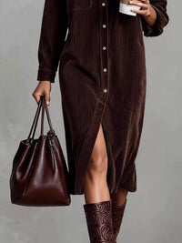Person wearing a brown dress and holding a brown leather bag against a gray background