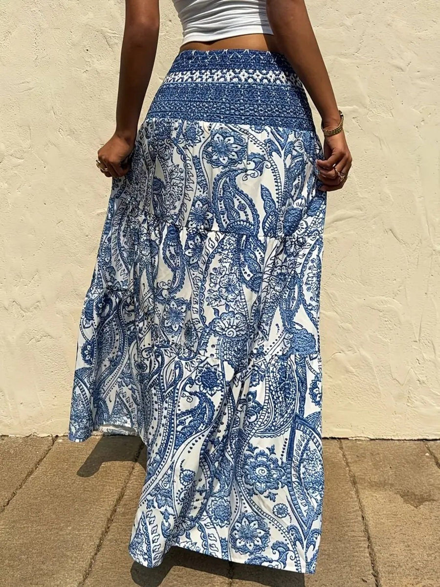 Person wearing a blue and white patterned skirt against a beige wall.