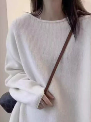 Light gray sweater worn by a person with a brown strap over the shoulder.