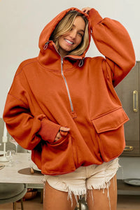 Person wearing a rust-colored hoodie in a kitchen setting