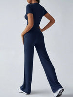 Person wearing a navy blue jumpsuit on a light gray background