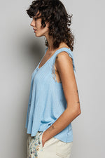 Woman wearing a light blue sleeveless top against a gray background