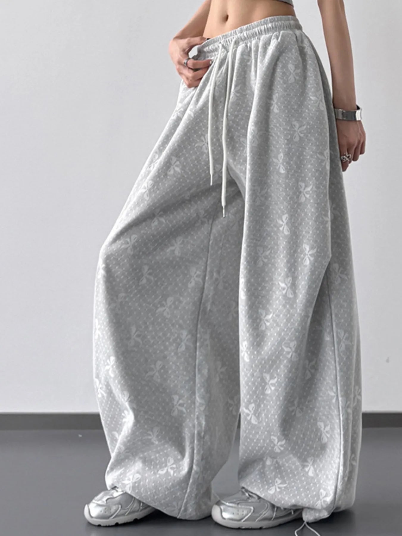 Person wearing gray wide-leg pants against a plain background