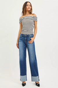 Woman wearing a striped off-shoulder top and blue jeans on a white background
