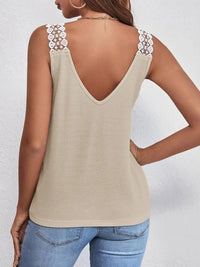 Beige tank top with floral straps worn by a person on a white background