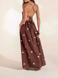 Brown dress with white polka dots worn by a model on a plain background