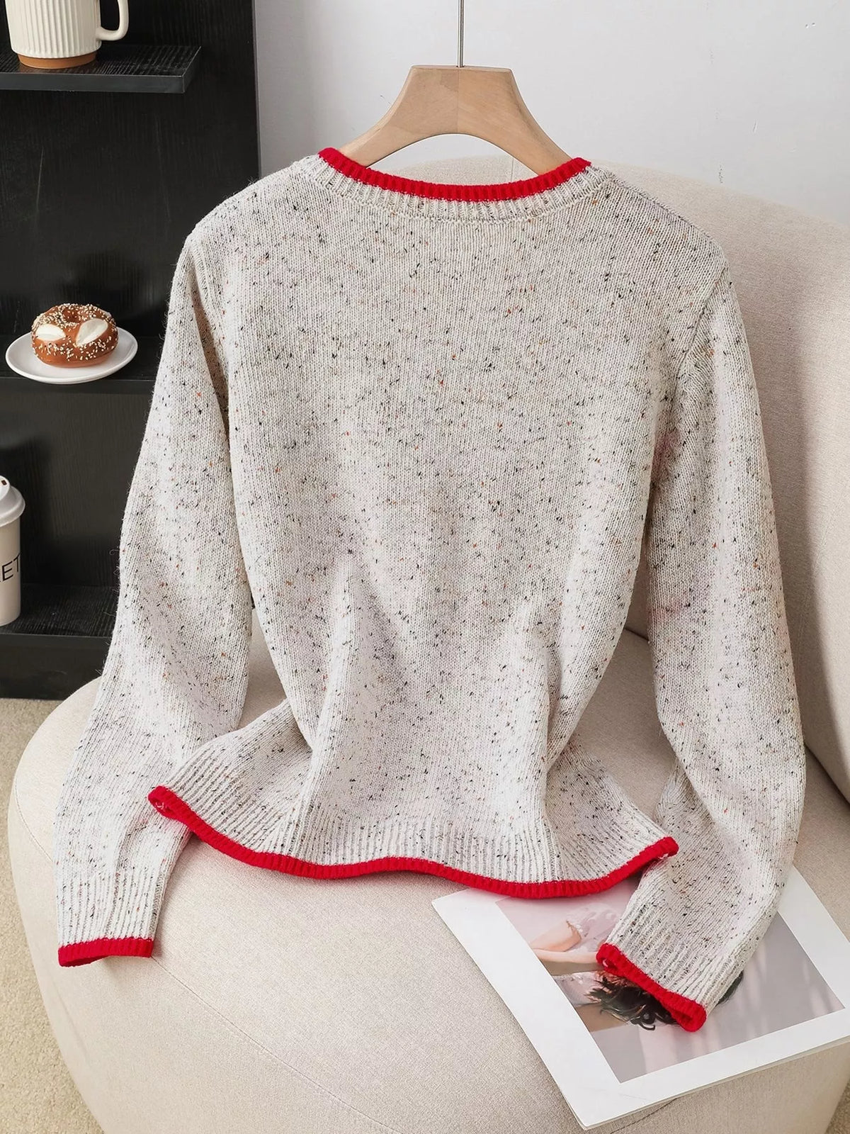 White sweater with red trim on a chair