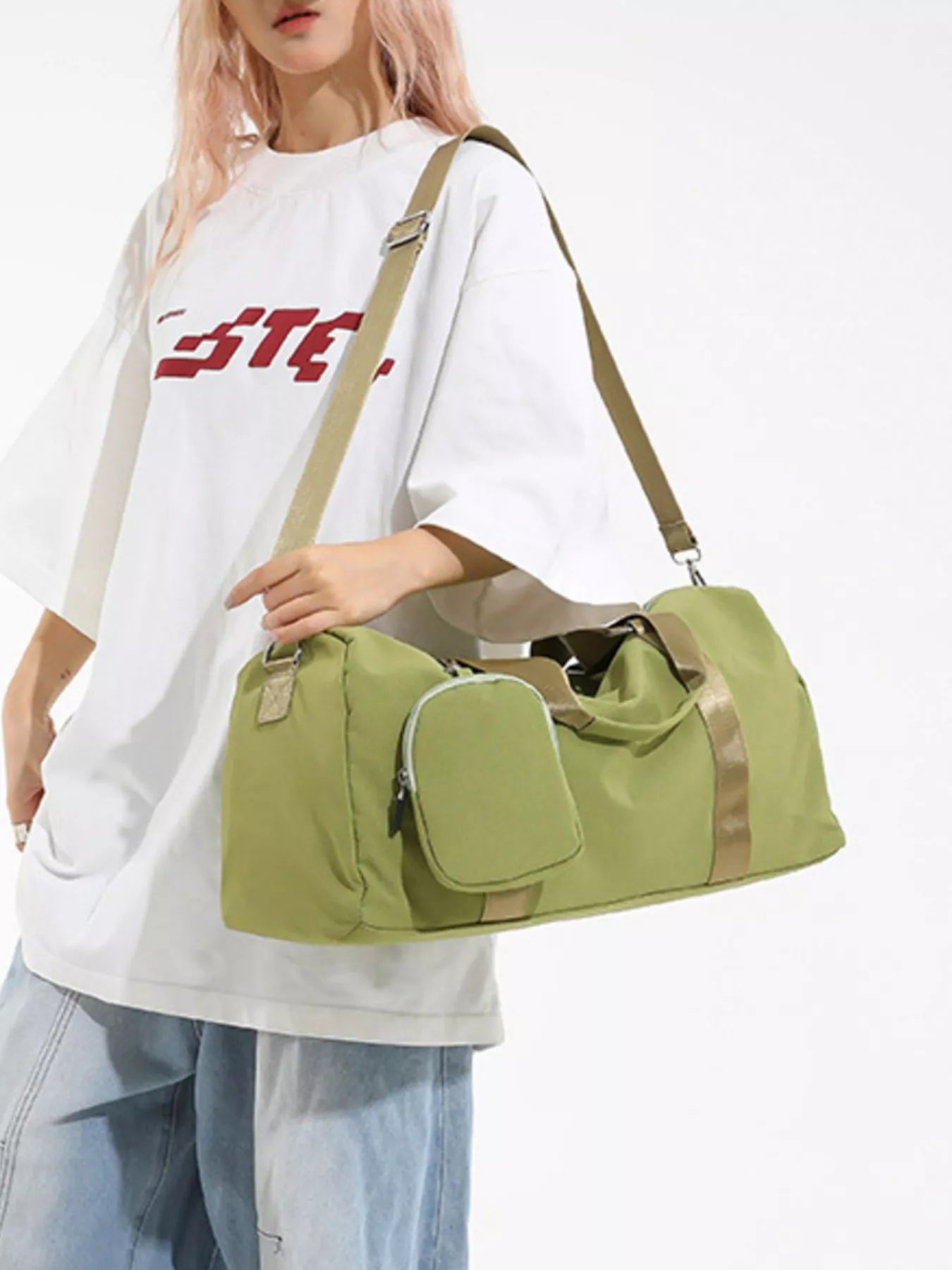 Person holding a green duffel bag with beige straps on a white background