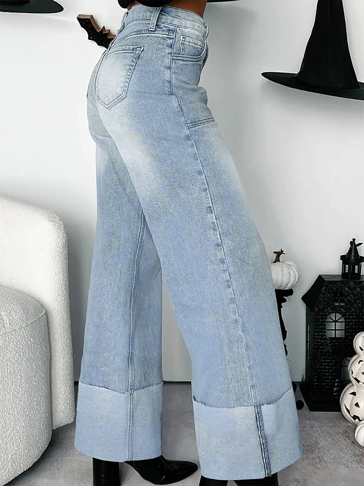 Light blue wide-leg jeans worn by a person indoors.
