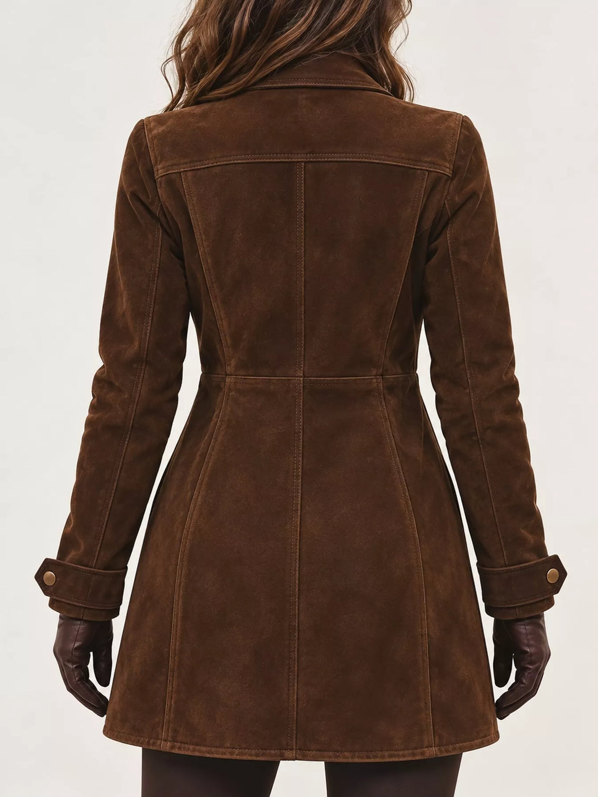 A woman viewed from the back wearing a brown suede or faux-suede coat with long sleeves, a collar, and buttoned cuffs, against a plain light background.
