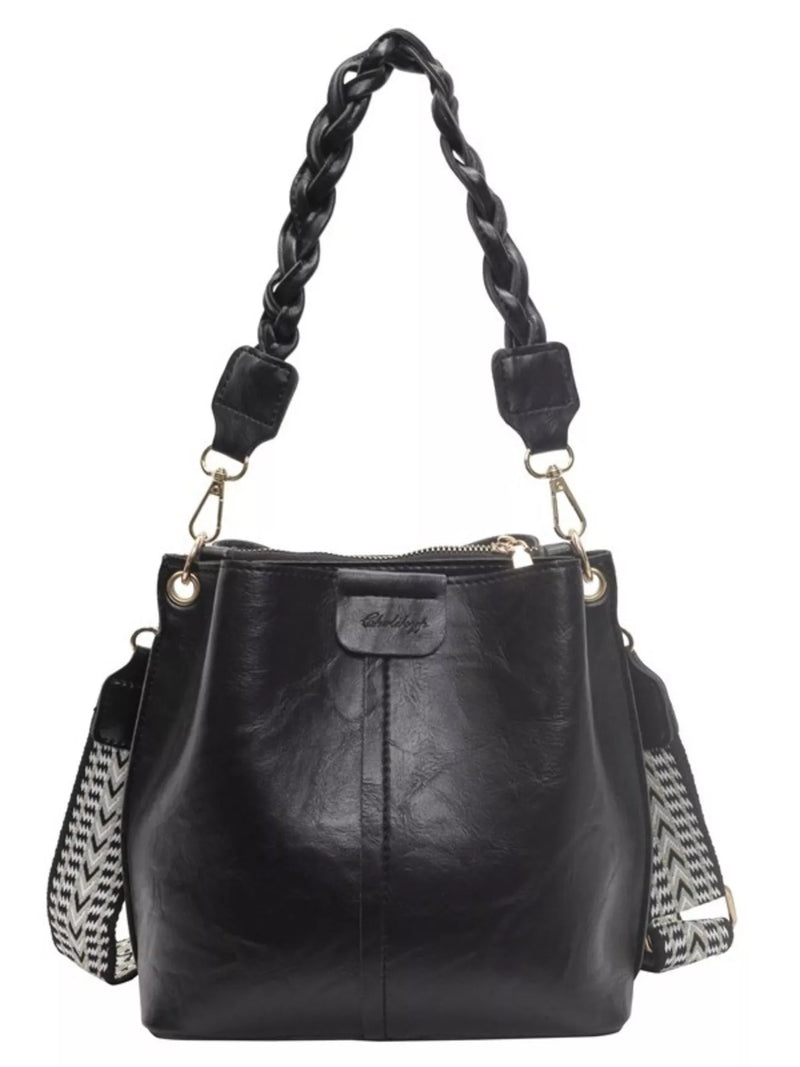 Black leather handbag with braided handle on a white background