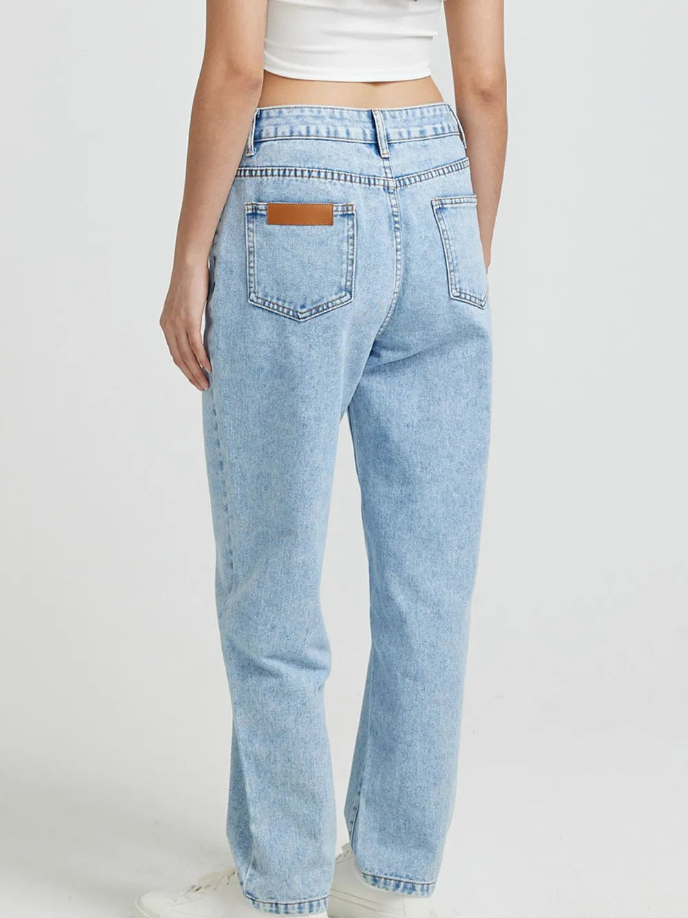 Light blue jeans worn by a person on a white background