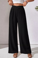 Person wearing black wide-leg pants with a white background