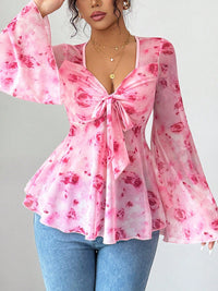 Pink floral blouse with long sleeves on a gray background