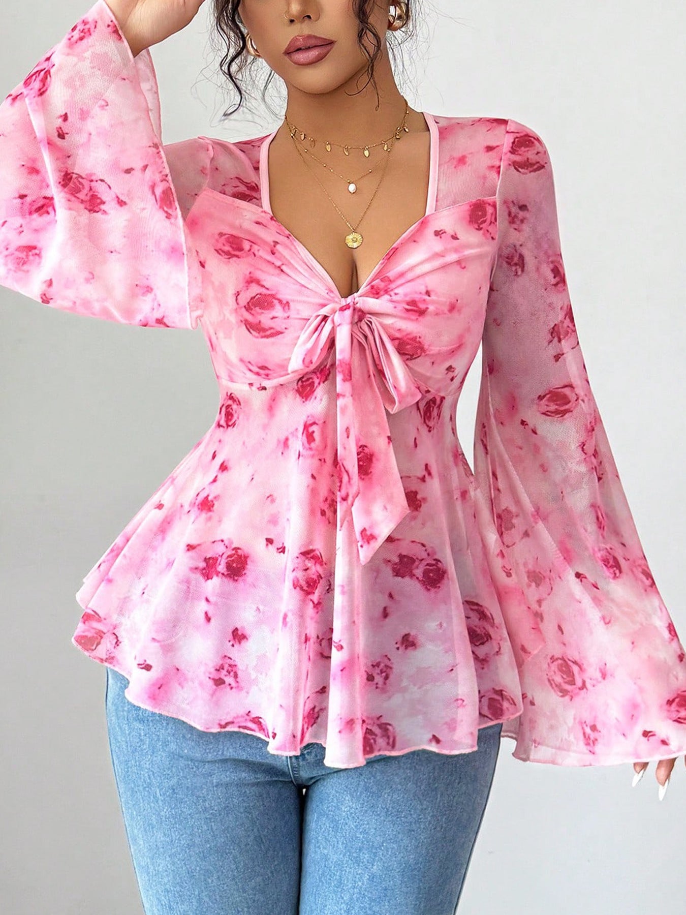 Pink floral blouse with long sleeves on a gray background