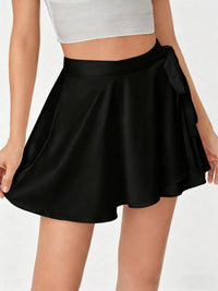 Black skirt worn by a person on a plain background