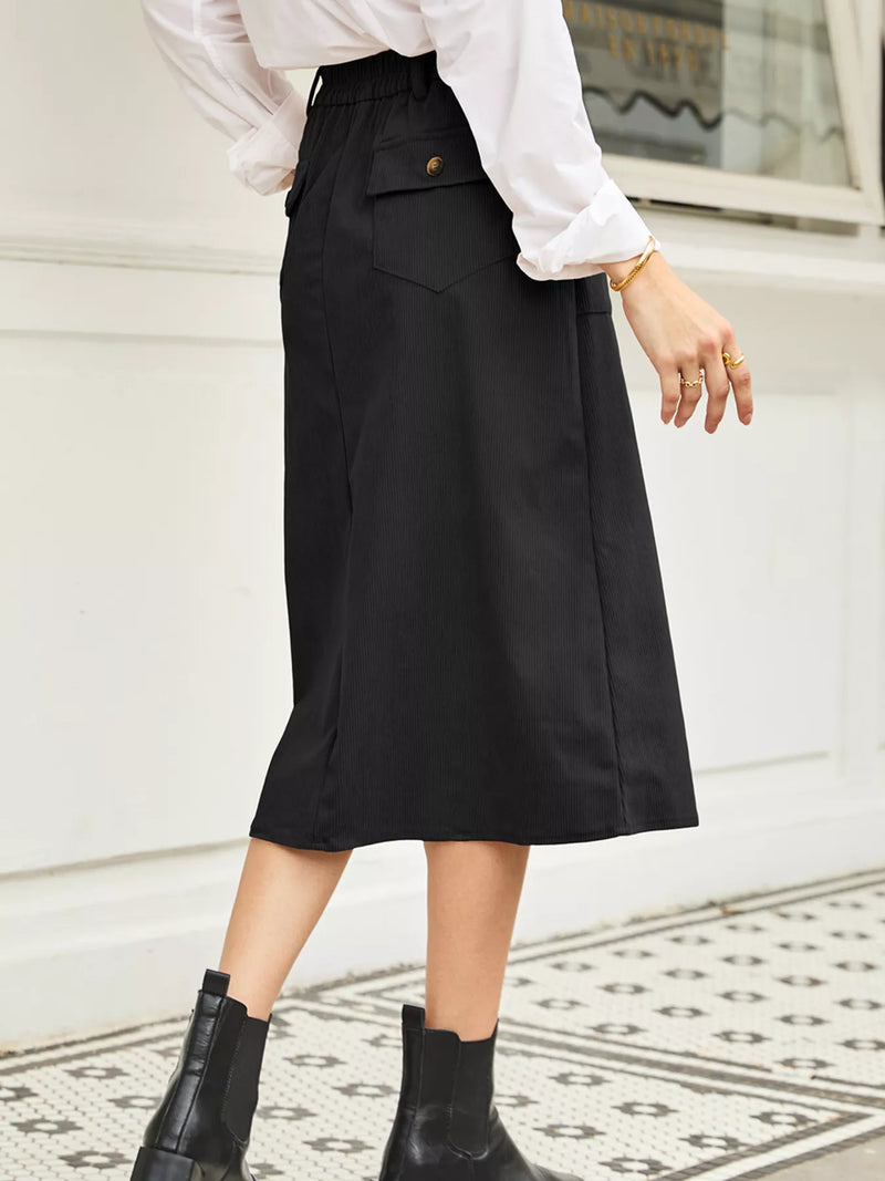 Person wearing a black skirt and white blouse in an indoor setting