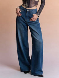 Person wearing blue wide-leg jeans on a plain background