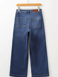 Blue jeans on a hanger against a white background
