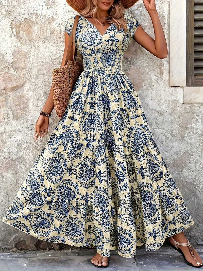 Woman wearing a floral dress standing against a stone wall.