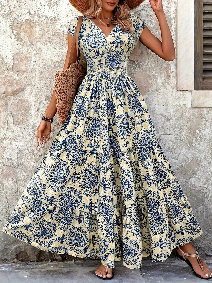 Woman wearing a floral dress standing against a stone wall.
