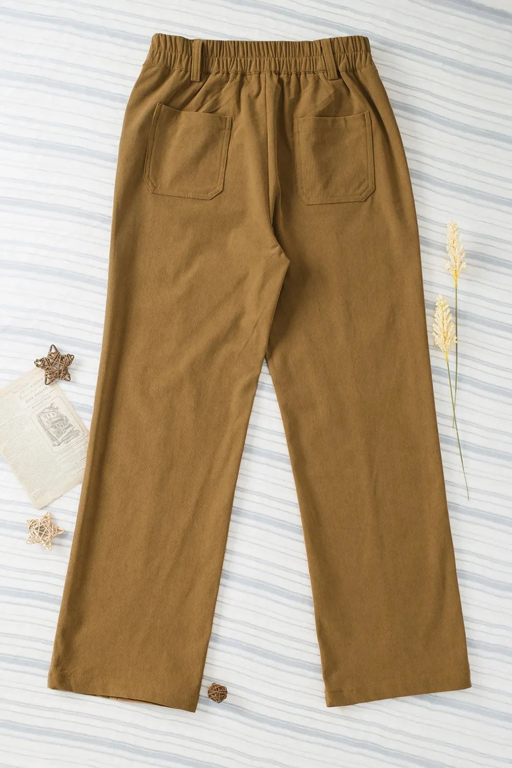 Brown pants on a white background with decorative elements.