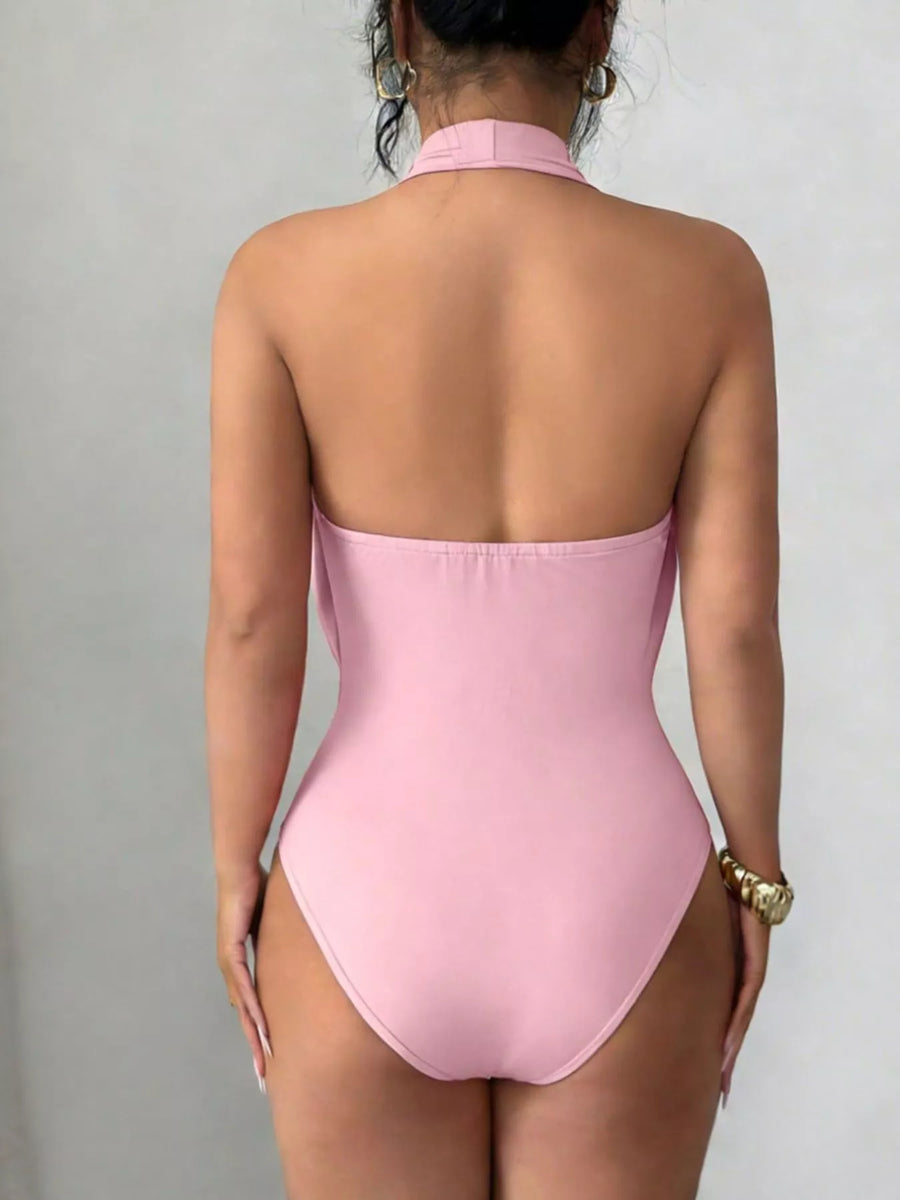 Pink swimsuit worn by a person on a plain background
