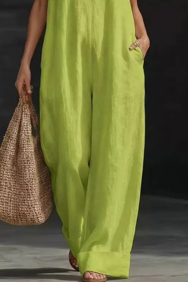 Person wearing bright green pants holding a woven bag against a dark background