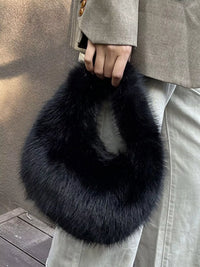 Person holding a black fur bag with a neutral background