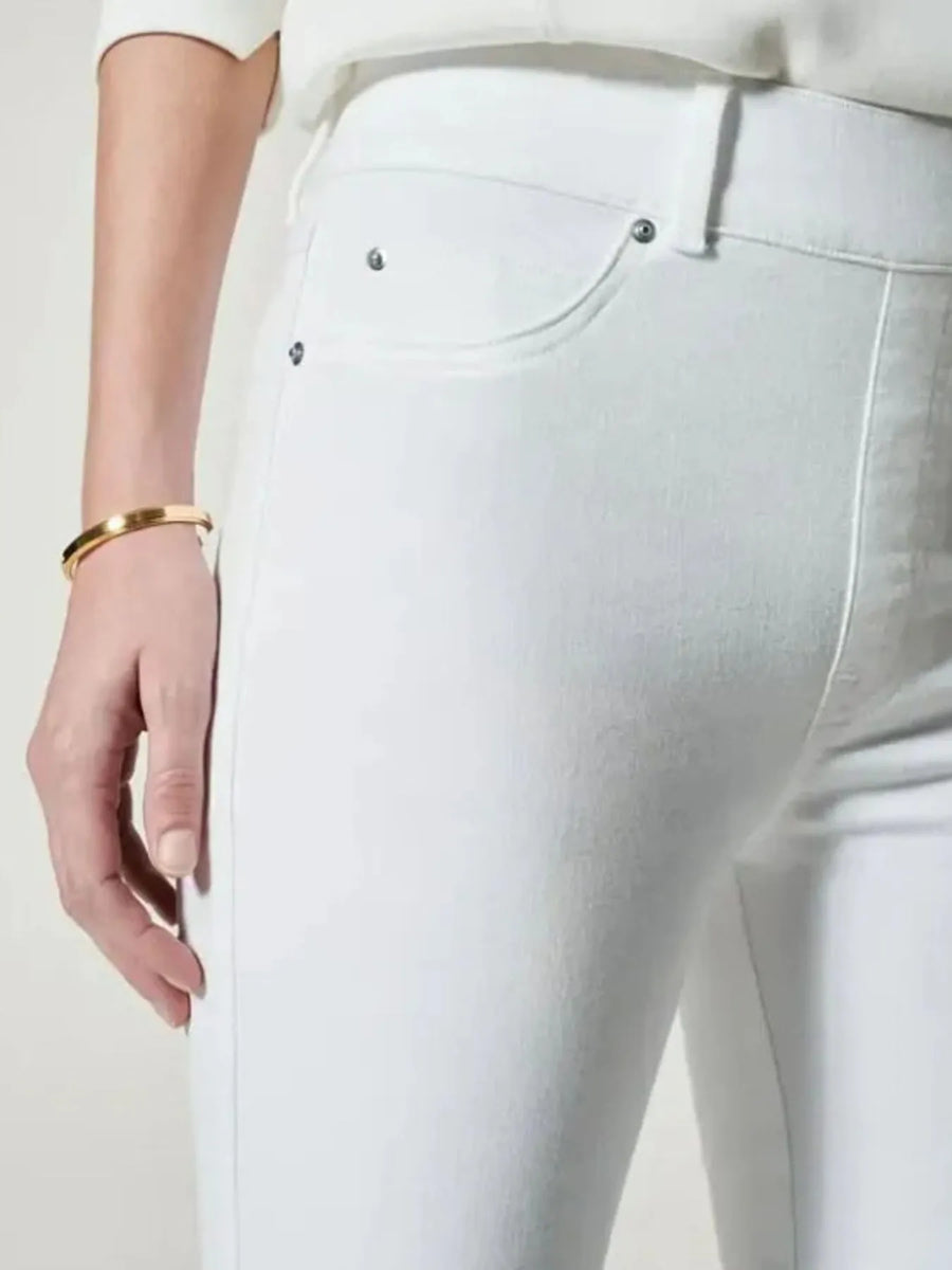 White pants with a close-up of a pocket on a plain background