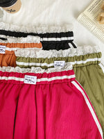 Set of colorful underwear with lace details on a white surface.
