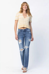 Woman wearing a yellow striped shirt and blue jeans on a white background