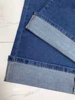 Close-up of blue denim fabric on a white marble surface
