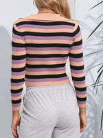 A woman shown from the back wearing a fitted long-sleeve ribbed knit top with horizontal stripes in peach, lavender, and black, paired with light gray sweatpants.