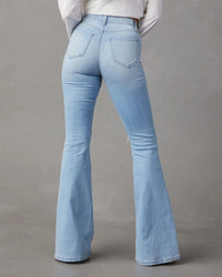 Light blue flared jeans on a gray background