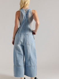 Person wearing a denim overalls on a plain background