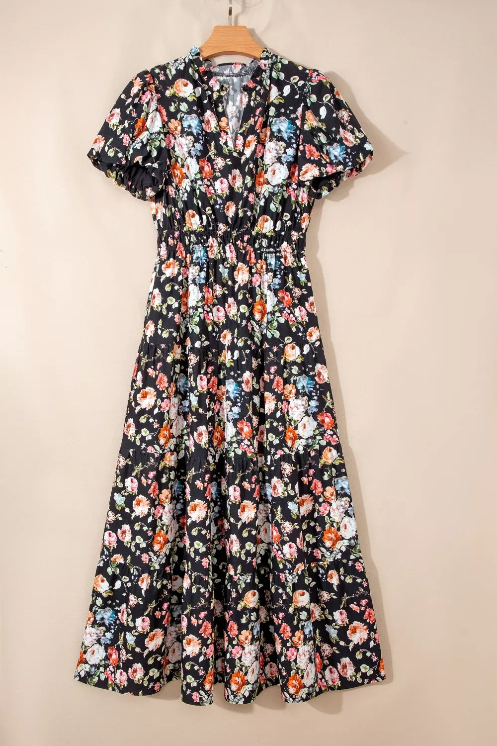 Floral dress on a hanger against a beige background