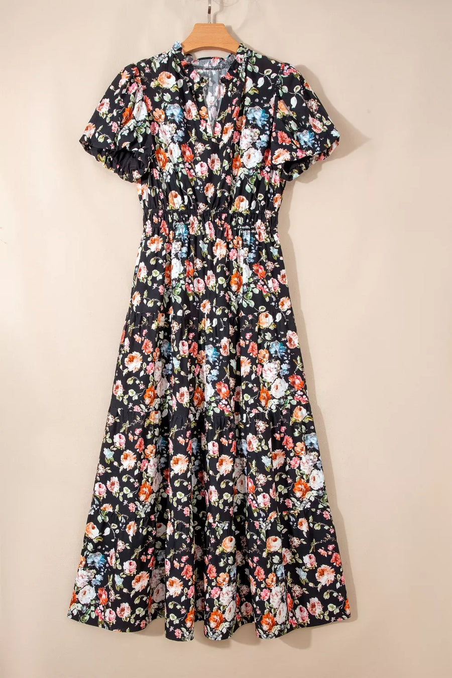 Floral dress on a hanger against a beige background
