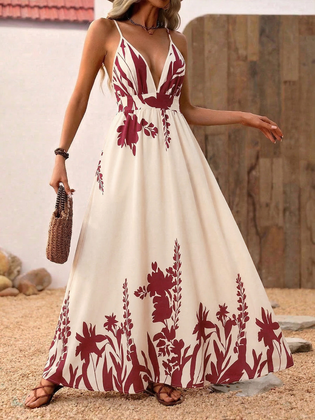 Woman wearing a white dress with red floral patterns on a sandy background